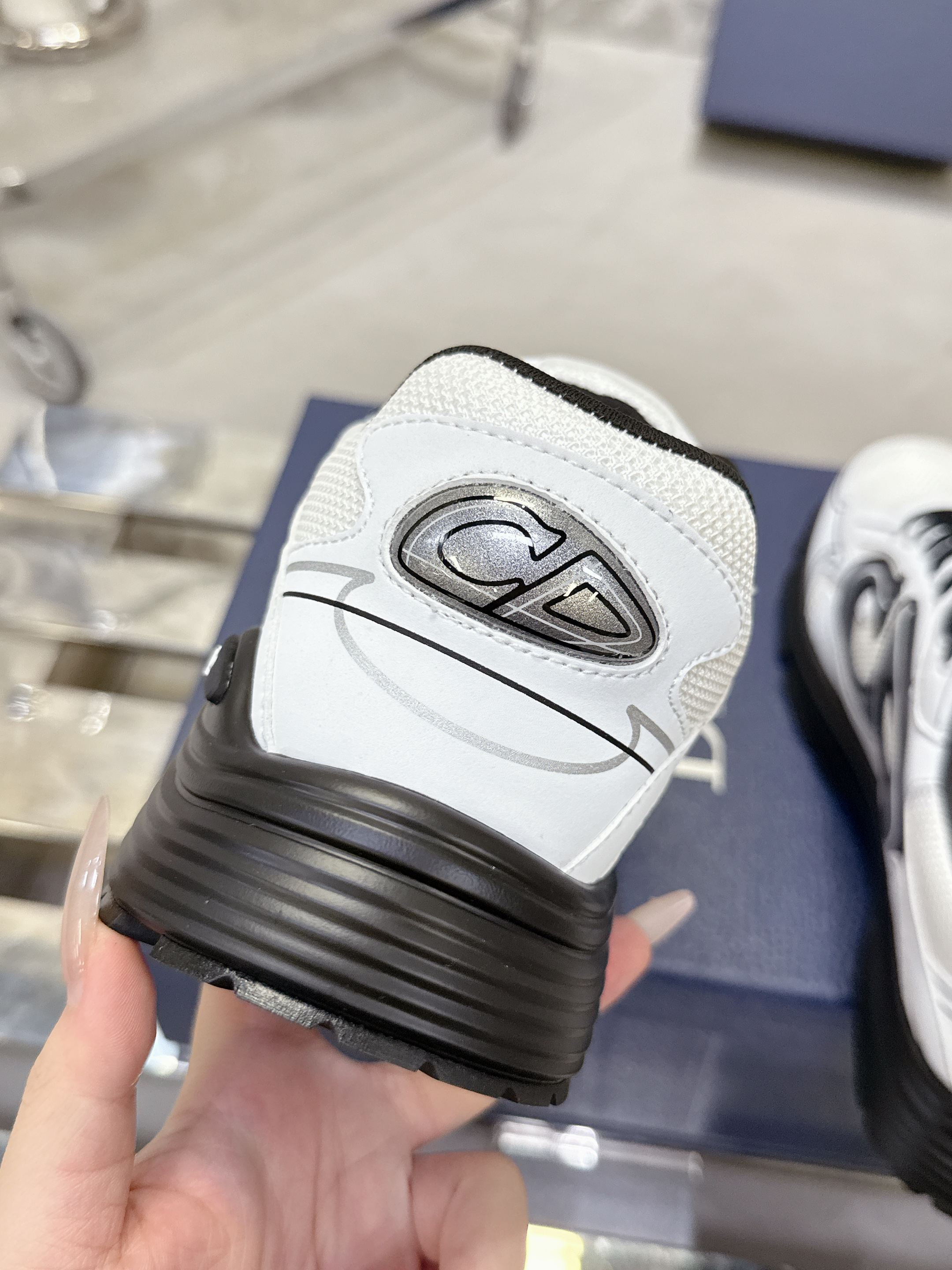 White Dior sneaker heel with black sole and embossed logo, close-up