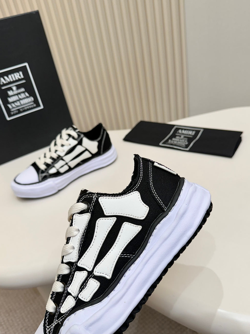Black and white low-top lace-up sneakers with white panel overlays and cushioned sole