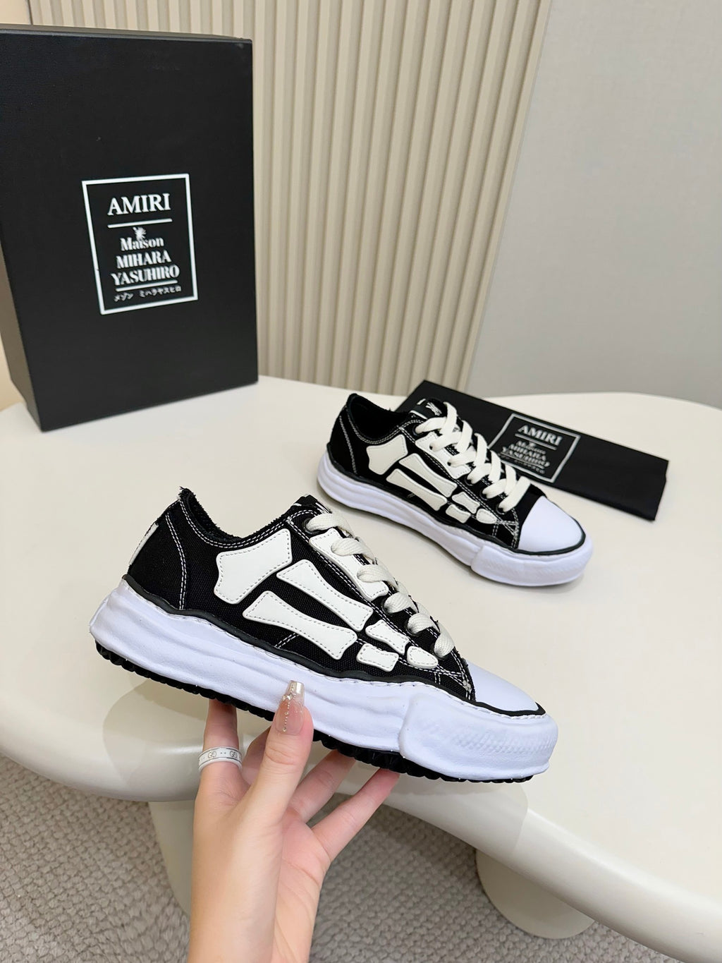 Pair of black and white low-top sneakers with bold panel design and white platform sole