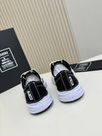 Back view of black and white low-top sneakers with white rubber soles