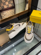 Fendi unisex sneakers on display: white-gray uppers with yellow interior and textured sole