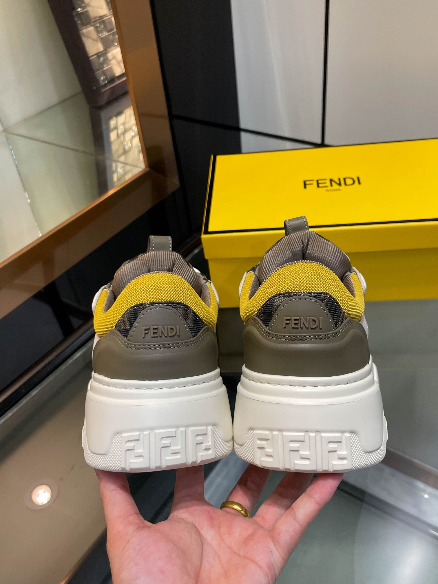 Fendi unisex sneakers rear view, white soles with yellow details and Fendi heel branding