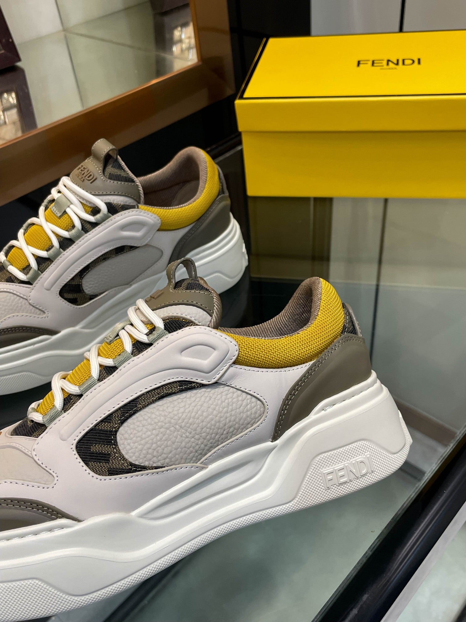 Fendi unisex sneakers, front pair in white and gray with yellow lace accents and bold sole