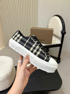 Burberry plaid lace-up sneaker in side view, black-and-white check fabric and white platform sole