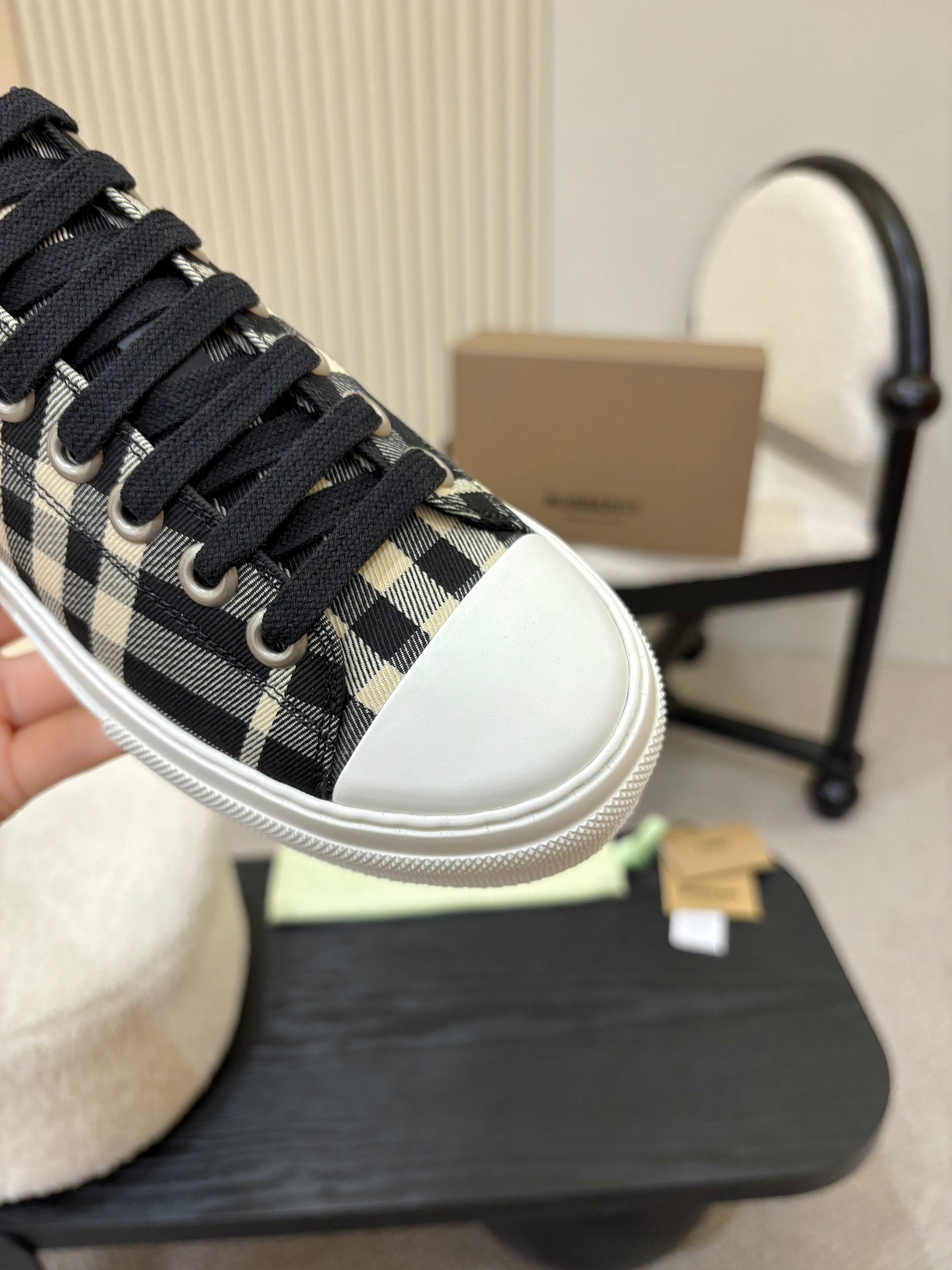 Burberry plaid sneaker close-up, black laces over black-and-white check textile