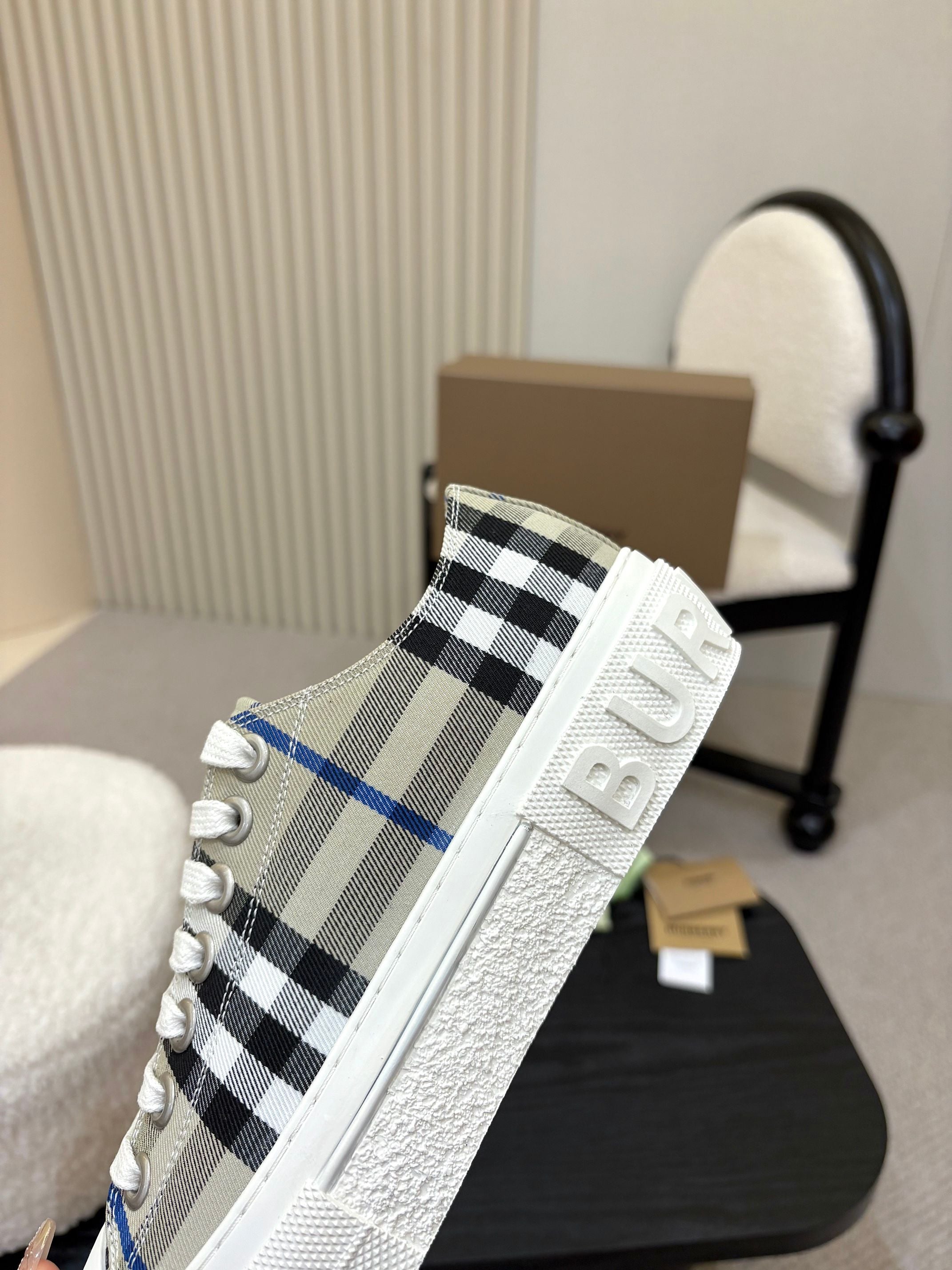 Burberry low-top sneaker side view, black and blue check upper with white sole