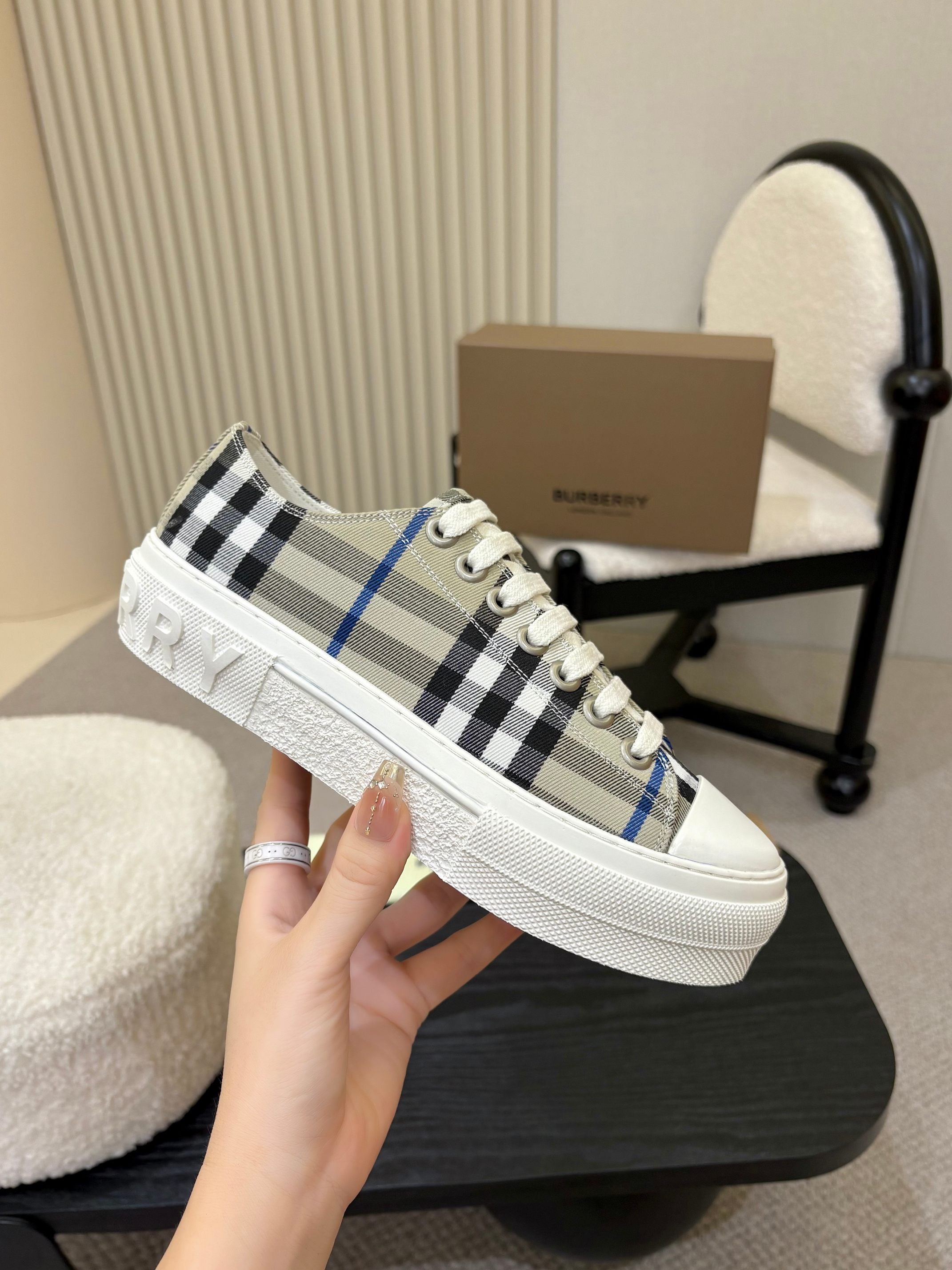 Burberry low-top sneaker on hand, white laces and black-blue check upper
