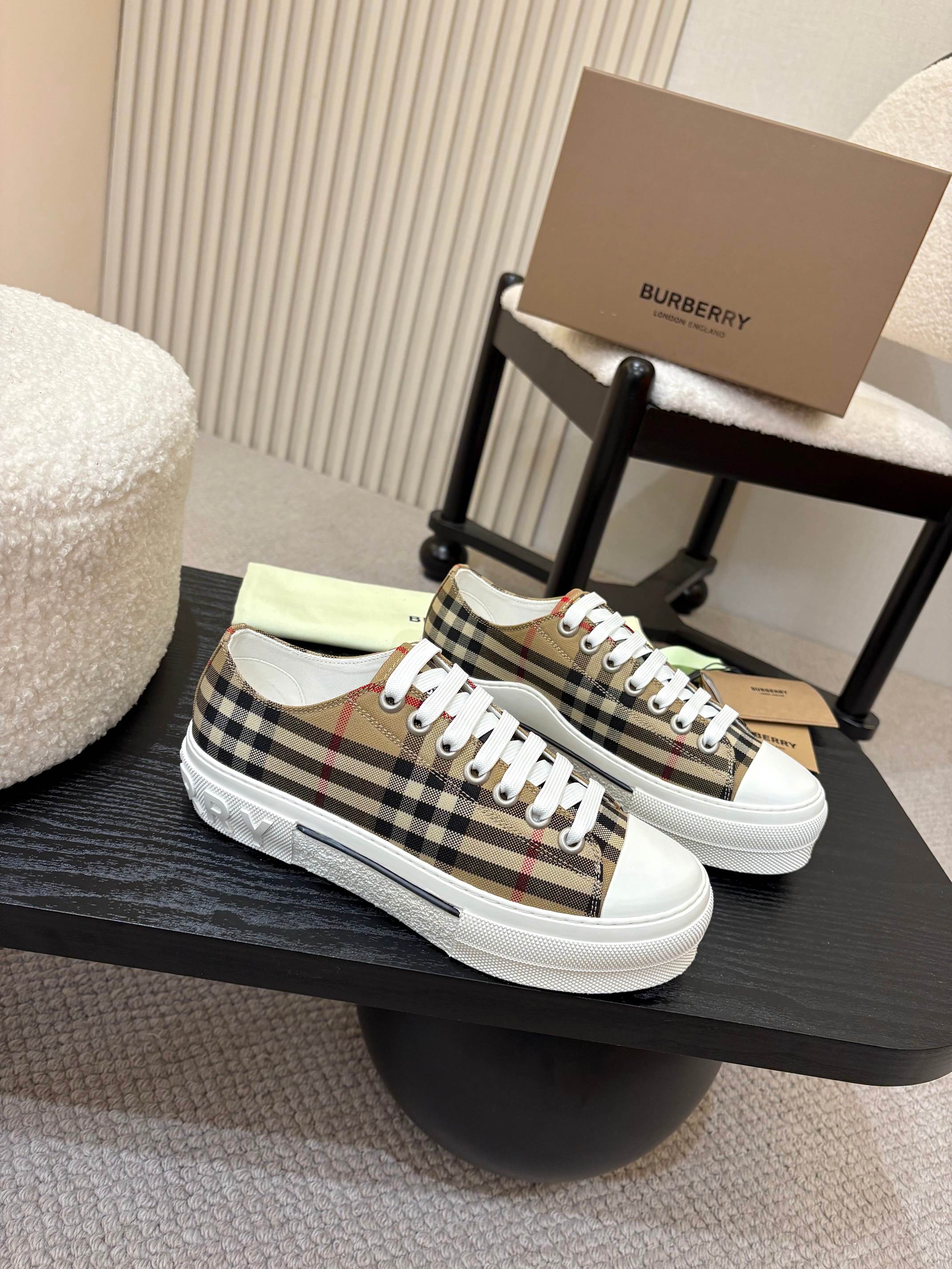 Burberry sneakers with plaid upper, white laces, and white rubber sidewall