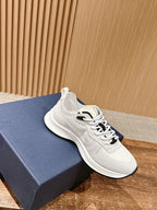 White Dior sneakers on blue shoebox, lace-up with black accent
