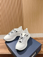White Dior sneakers on blue shoebox, lace-up with black heel tab