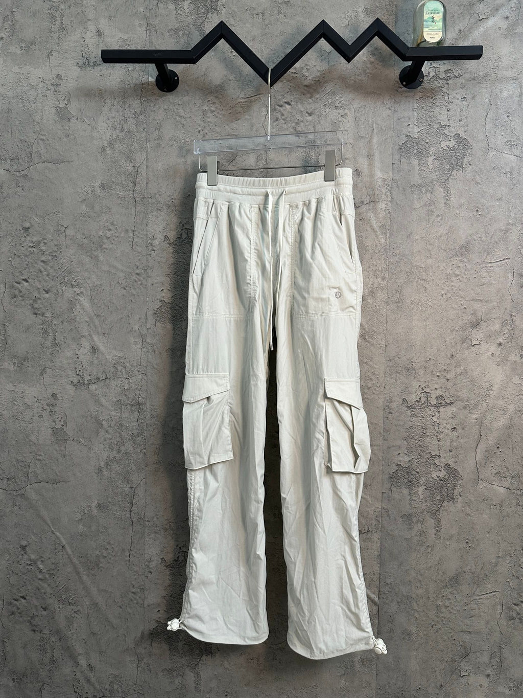 White cargo pants with drawstring waist and side flap pockets