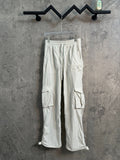 White cargo pants with drawstring waist and side flap pockets