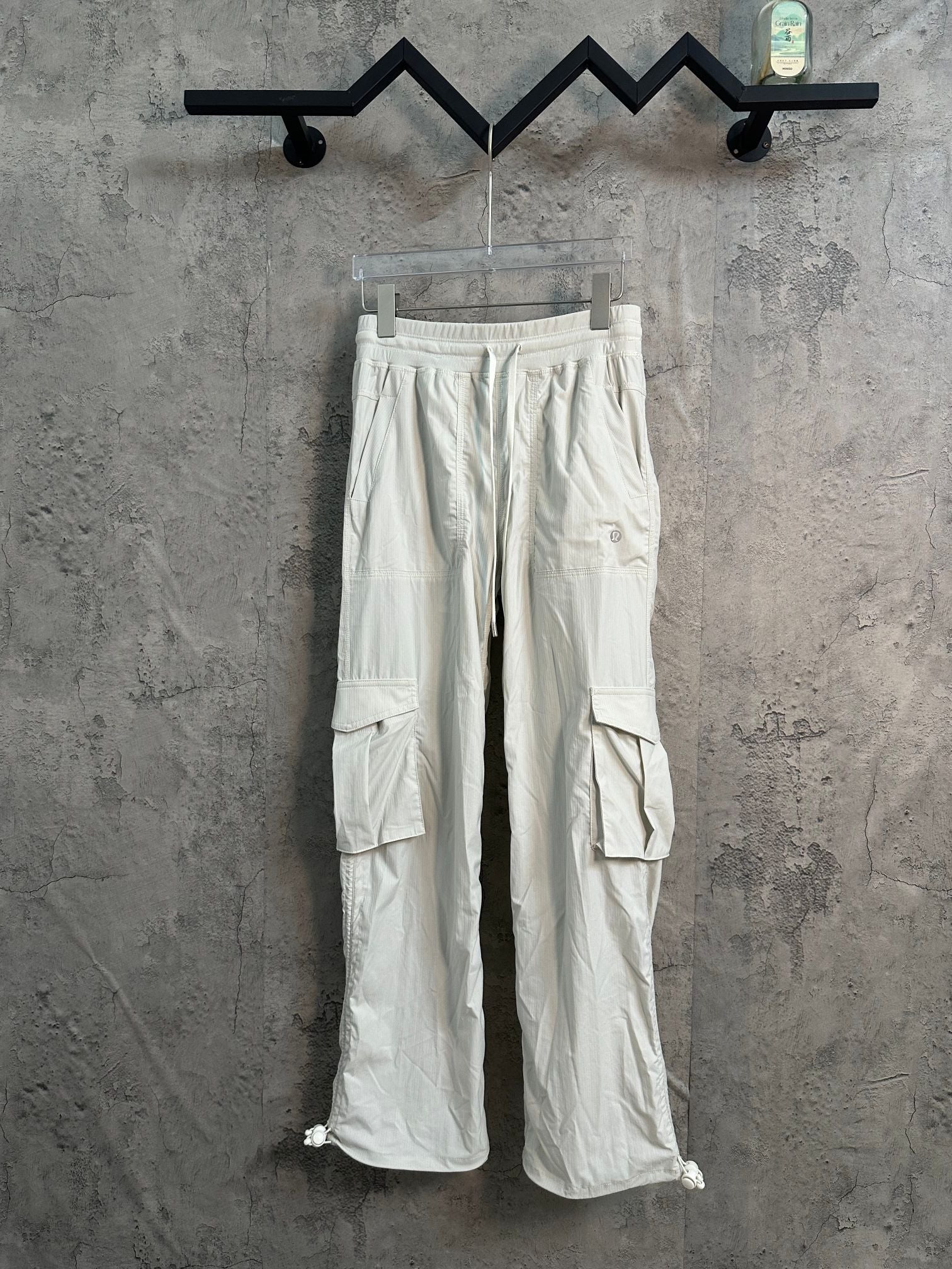 White cargo pants with drawstring waist and side flap pockets