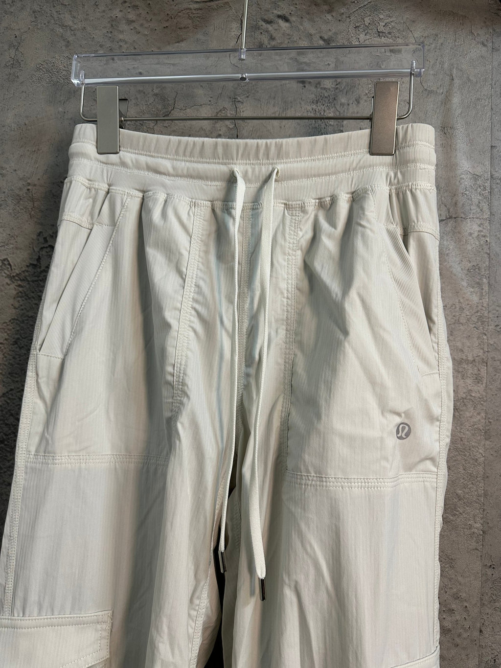 White cargo pants with elastic waistband and stitched pocket panels