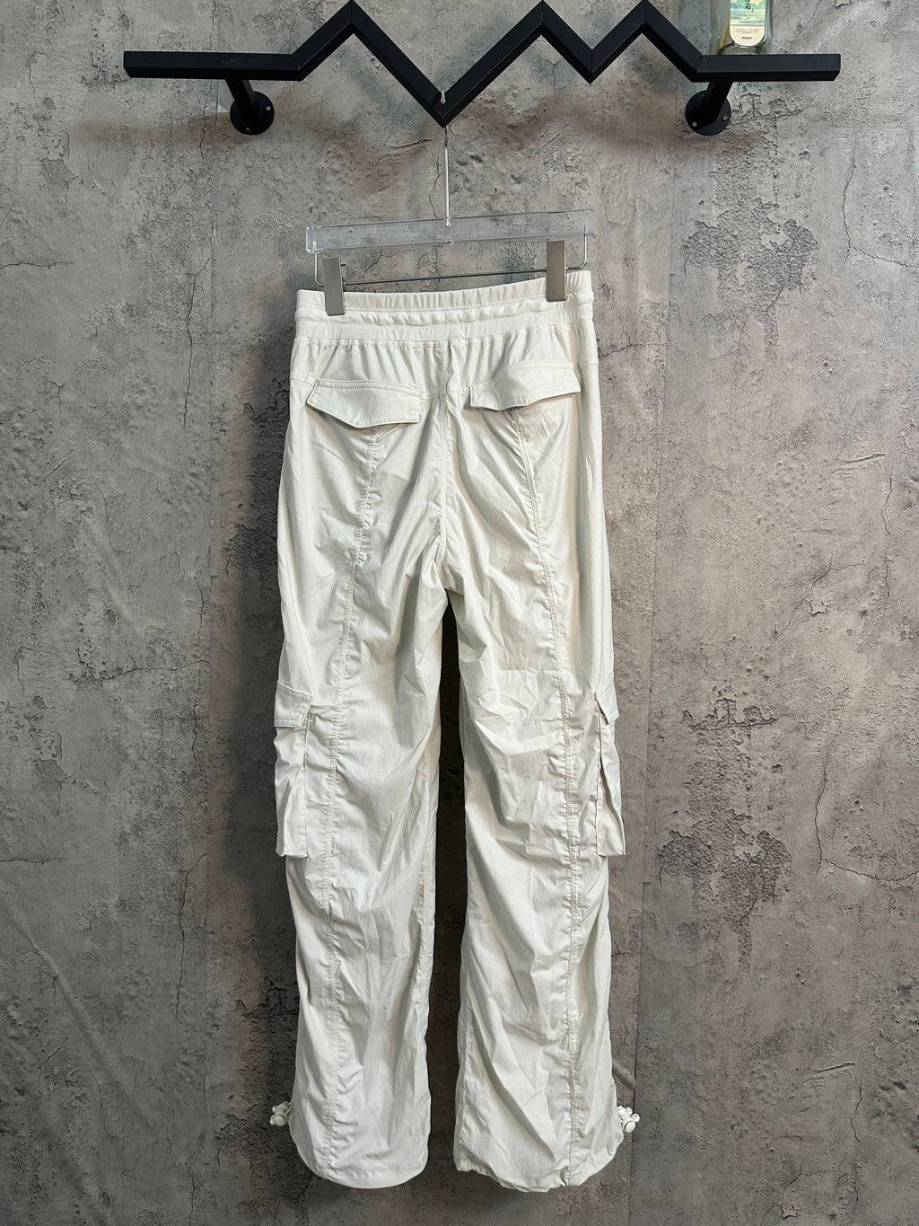 White cargo pants with elastic waistband and rear patch pockets