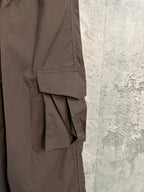 Brown cargo pants with layered pocket flaps and angled seam detailing