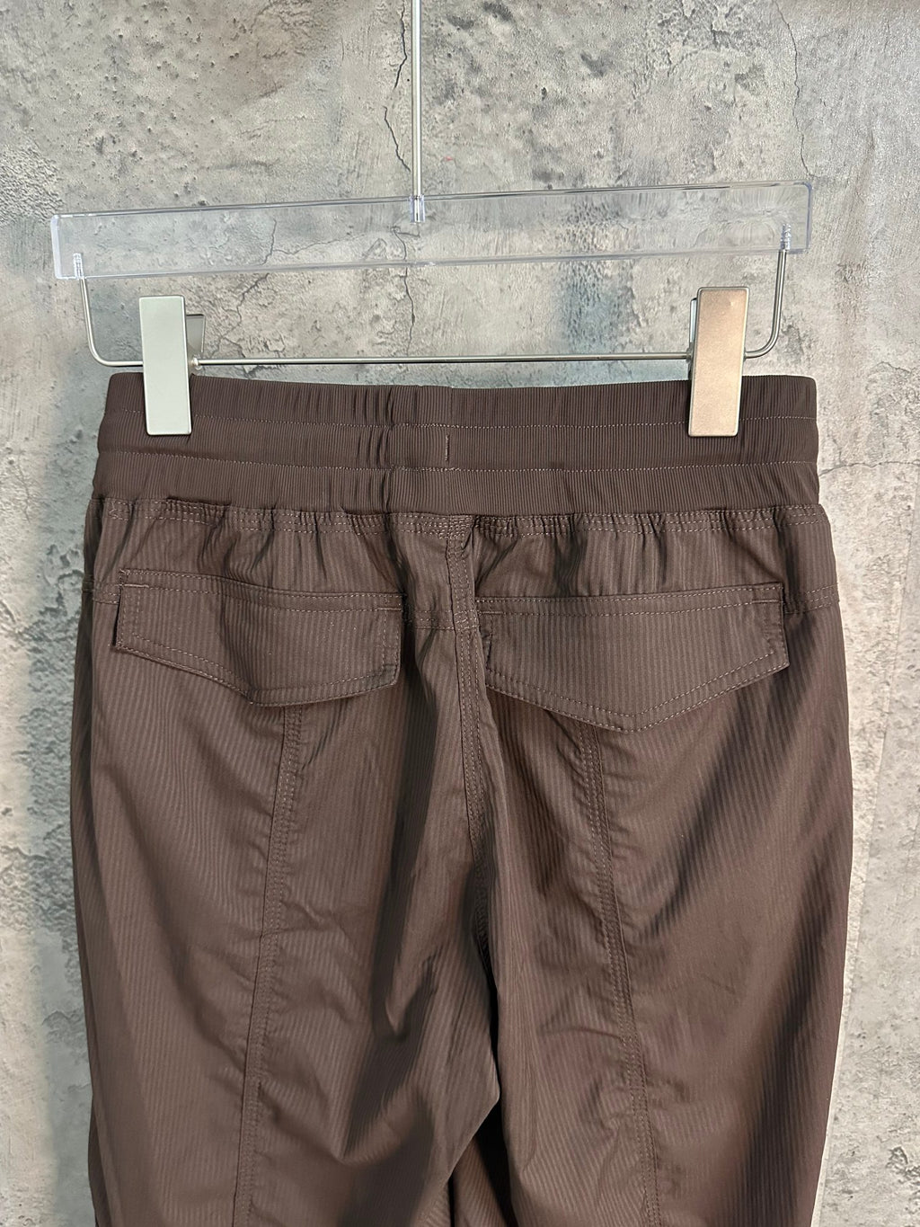 Dark brown cargo pants back view with gathered waist and flap cargo pockets