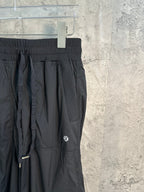 Black cargo pants detail with elastic waistband and utility pocket