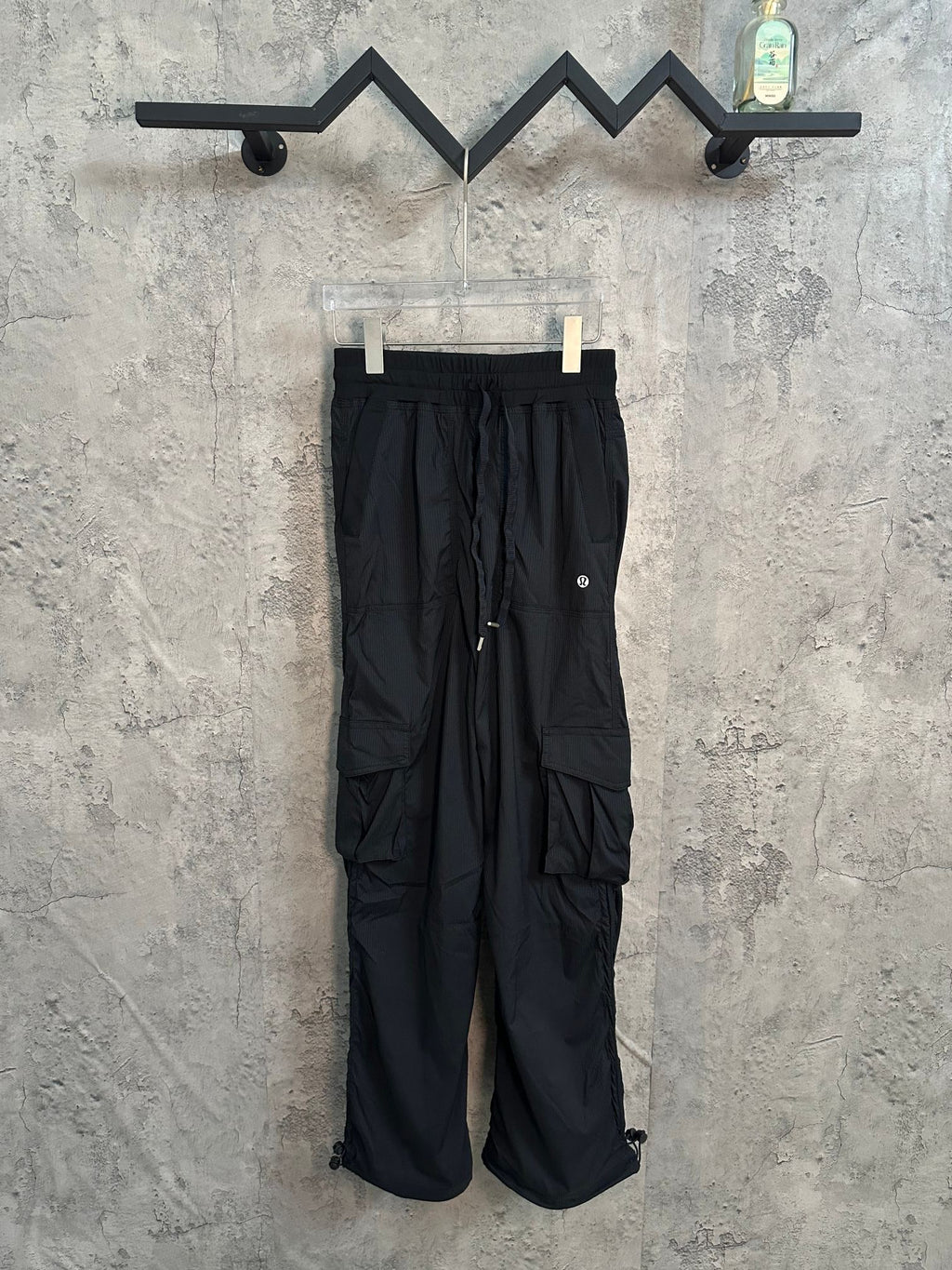 Black cargo-style pants with drawstring waist and side pockets