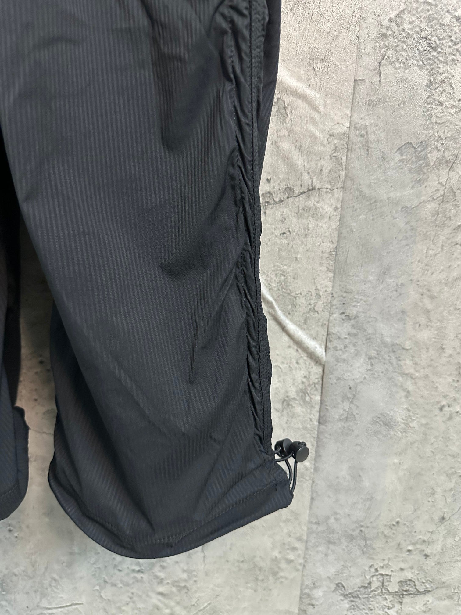 Black cargo pants with side tab and hem cinch detail