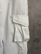 White cargo pants with layered cargo pocket detail and zipper-free side seam