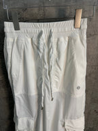 White cargo pants with pleated waistband and thigh cargo flap pockets