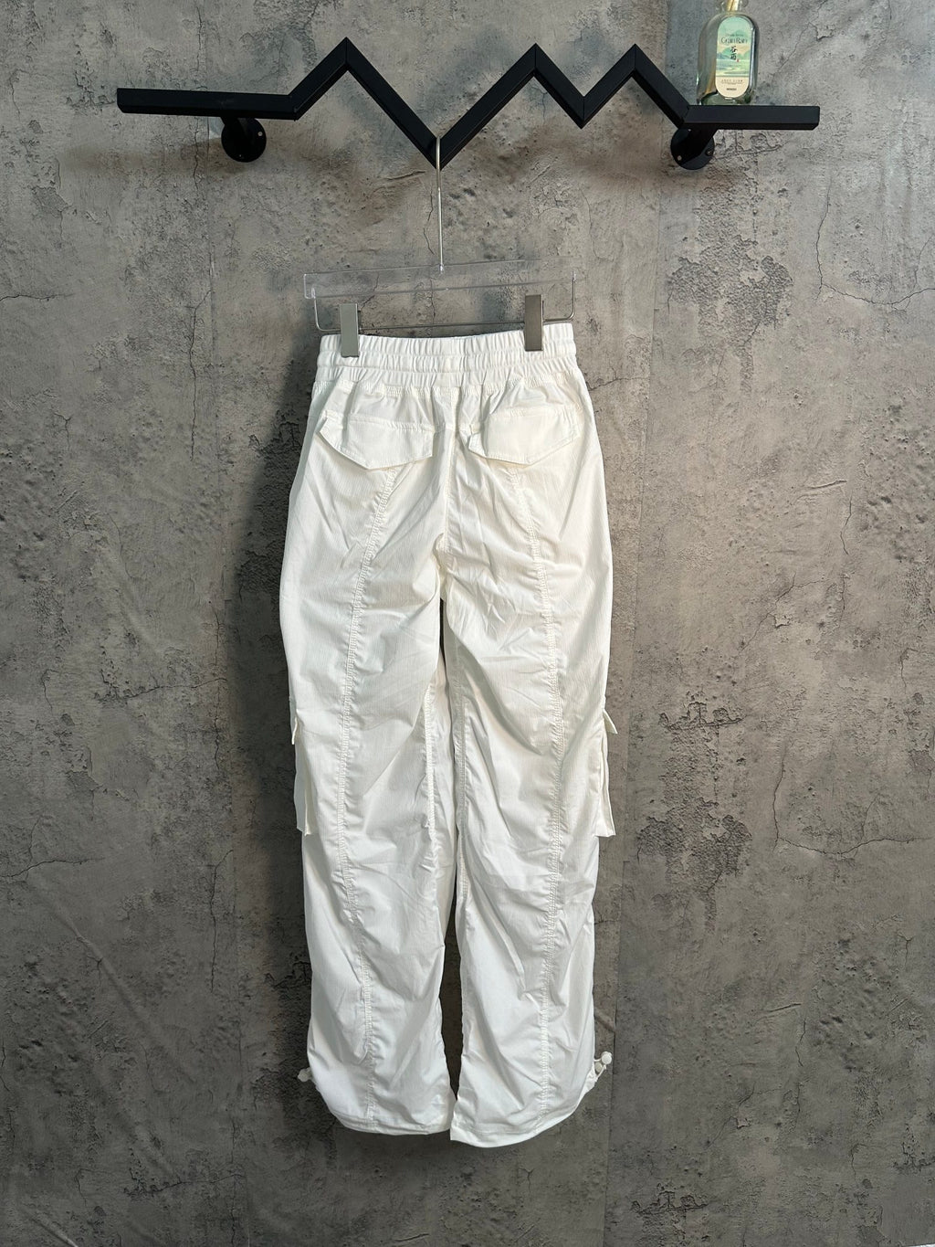 White cargo pants with elastic waistband and thigh cargo pockets, front view