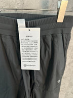 Dark gray cargo pants with tag and circular lululemon logo on pocket