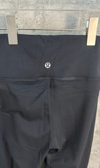 Black trousers with small oval logo at thigh