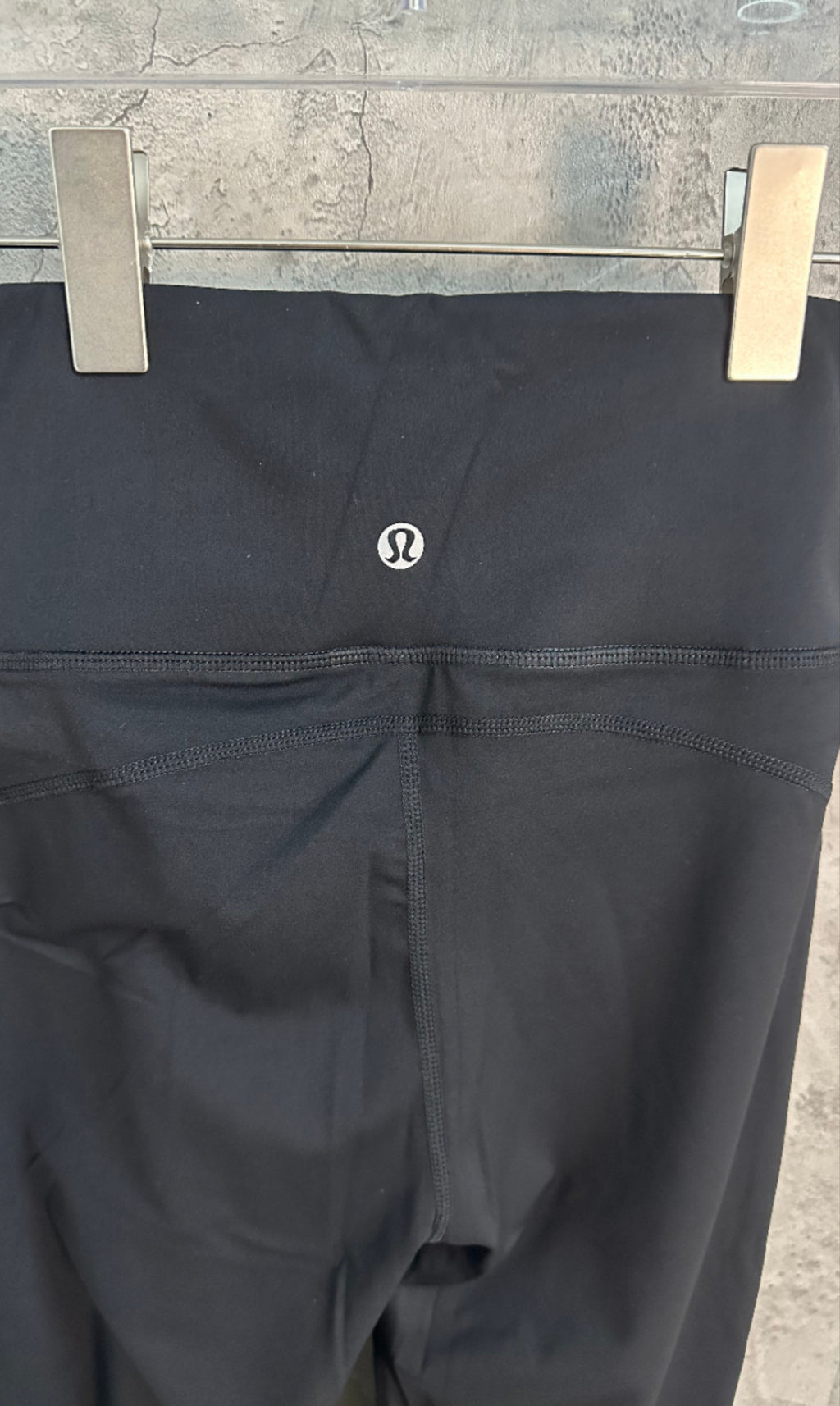 Black pants with small circular logo and front pocket seams