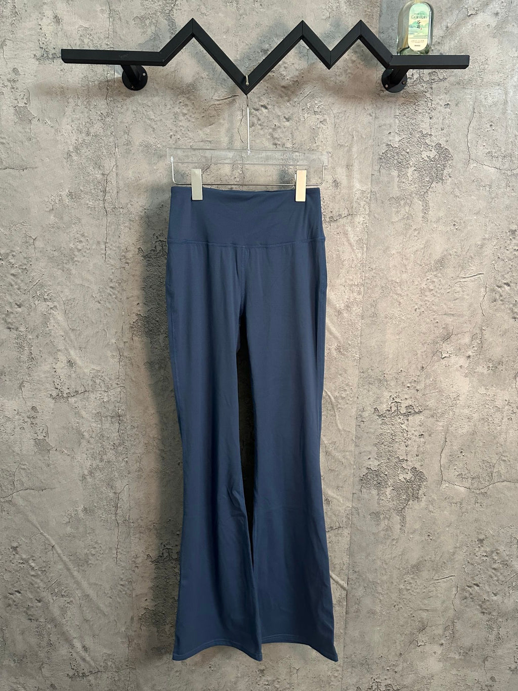 Blue flared pants with elastic waistband and seam detail, hanging on clips