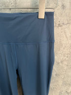 Blue pants waistband area with contrast-stitched seam and smooth fabric