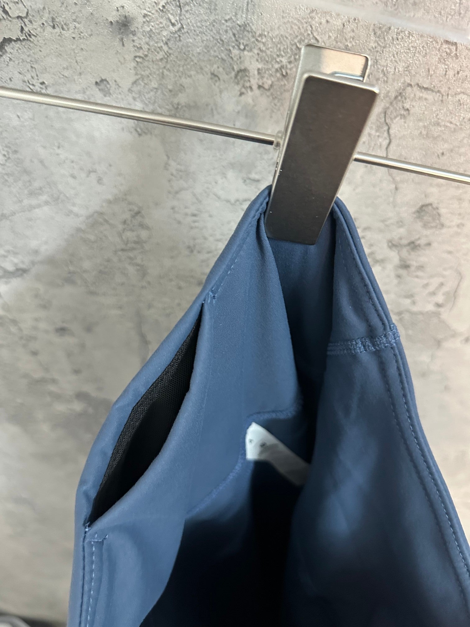 Blue athletic pants folded with visible inner waistband and side seam