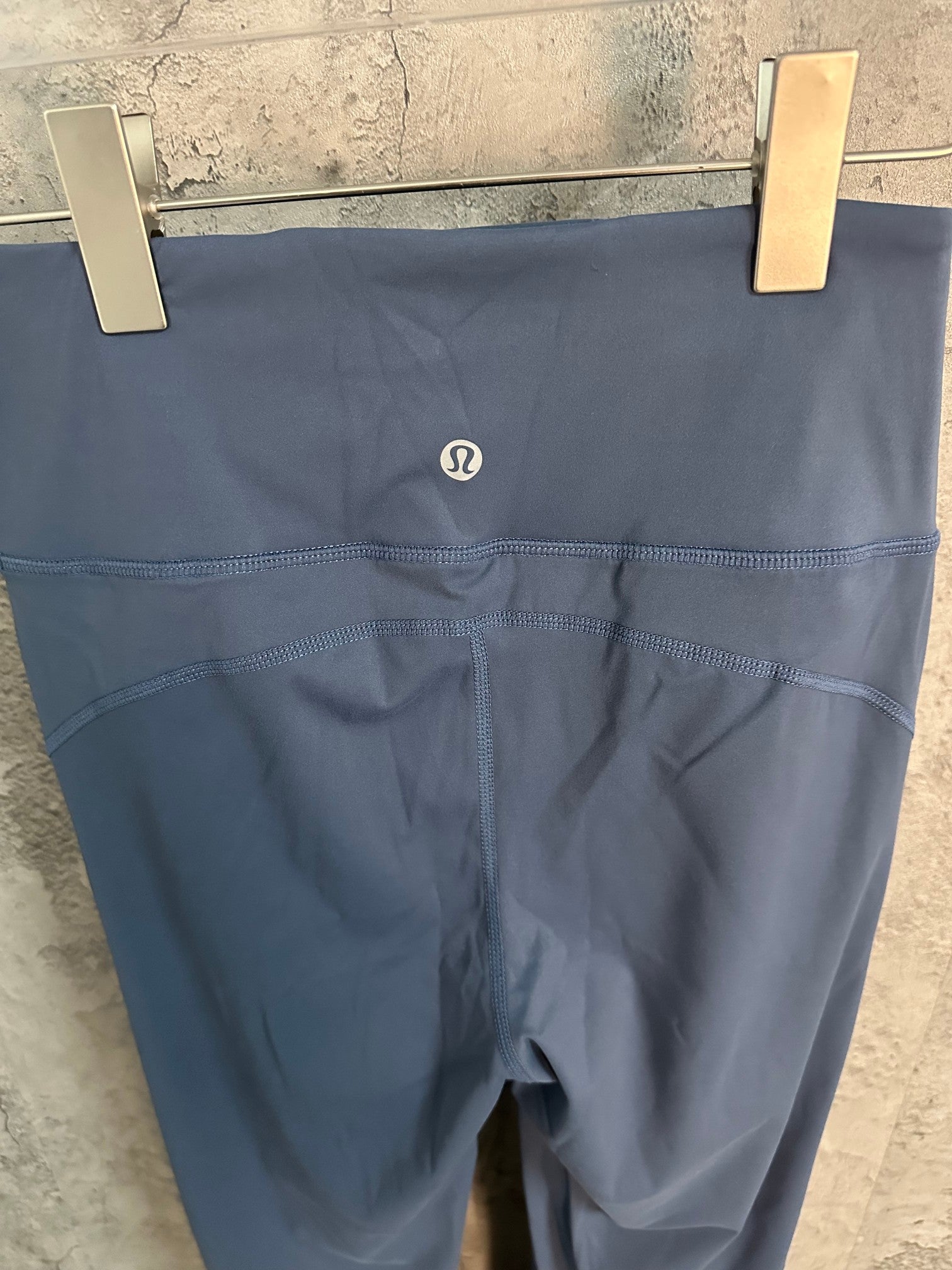 Blue athletic pants back view with small centered logo on waistband