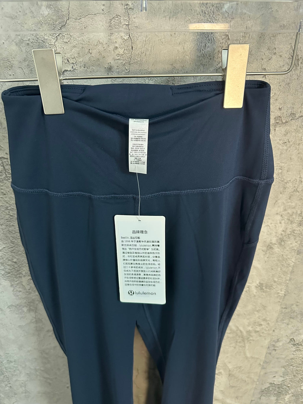 Blue athletic pants with hang tags on waistband and back seam detail