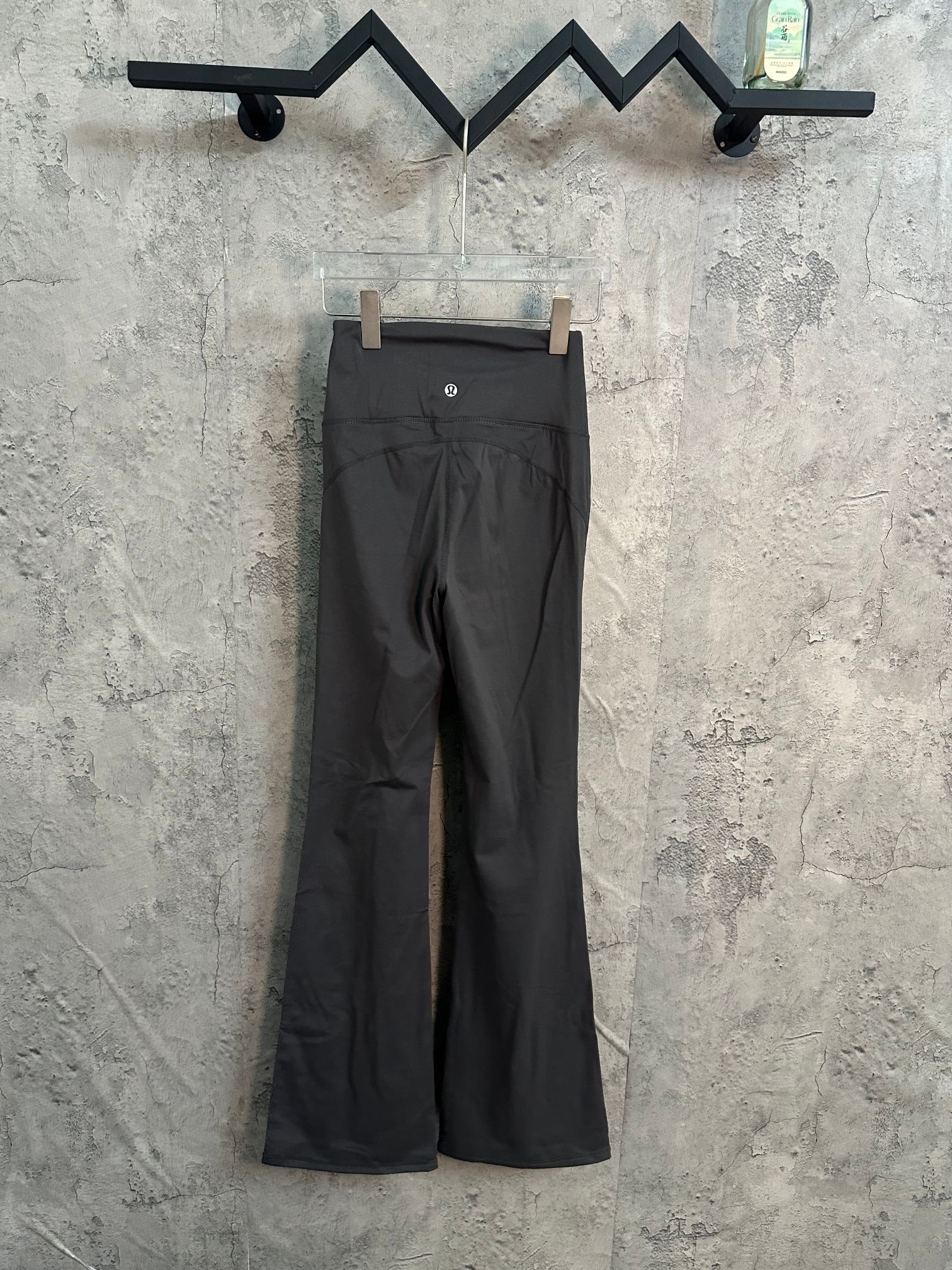 Dark charcoal wide-leg pants with smooth front panel and flat waistband