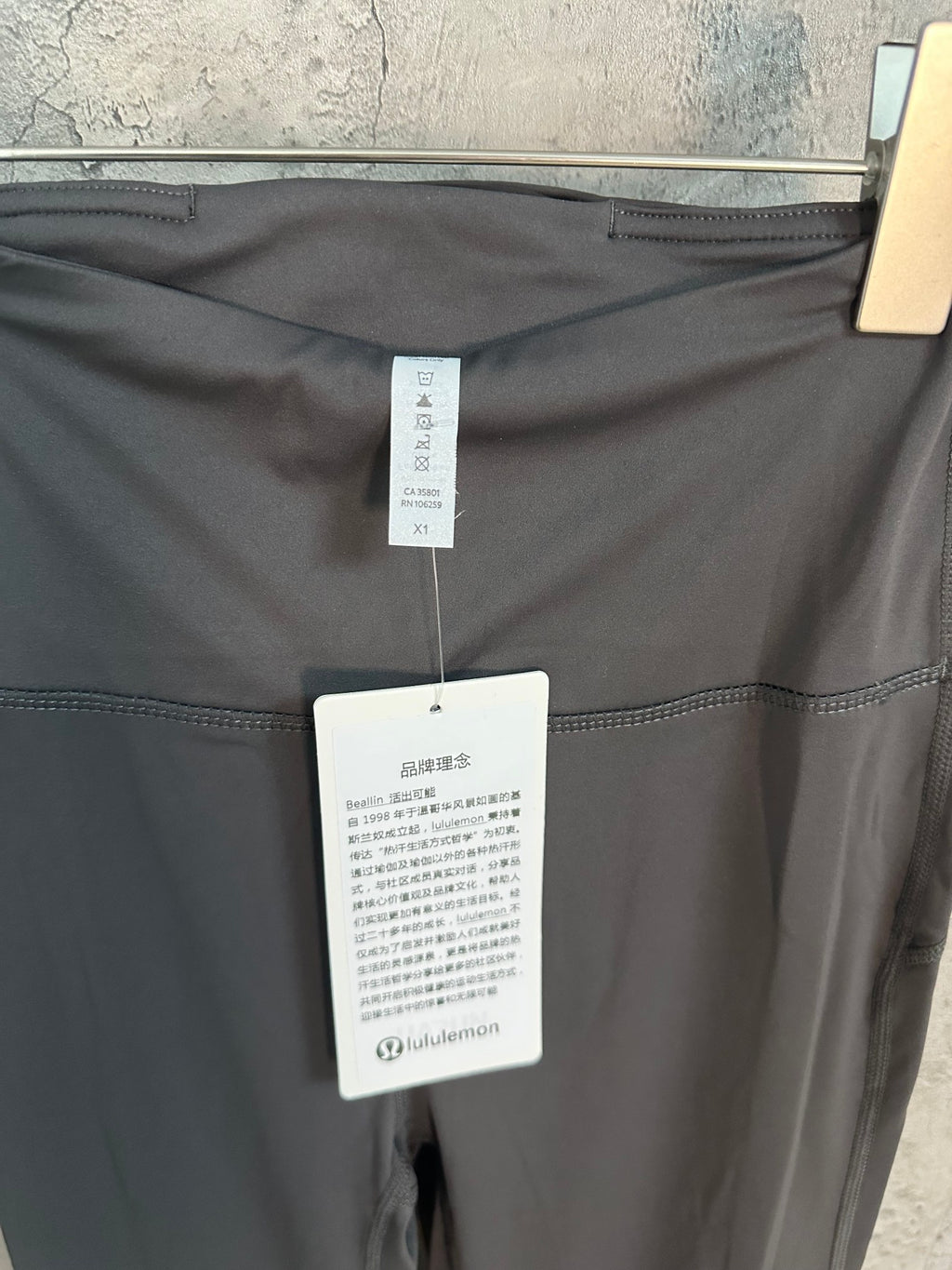 Dark gray pants with internal size and care labels at waistband
