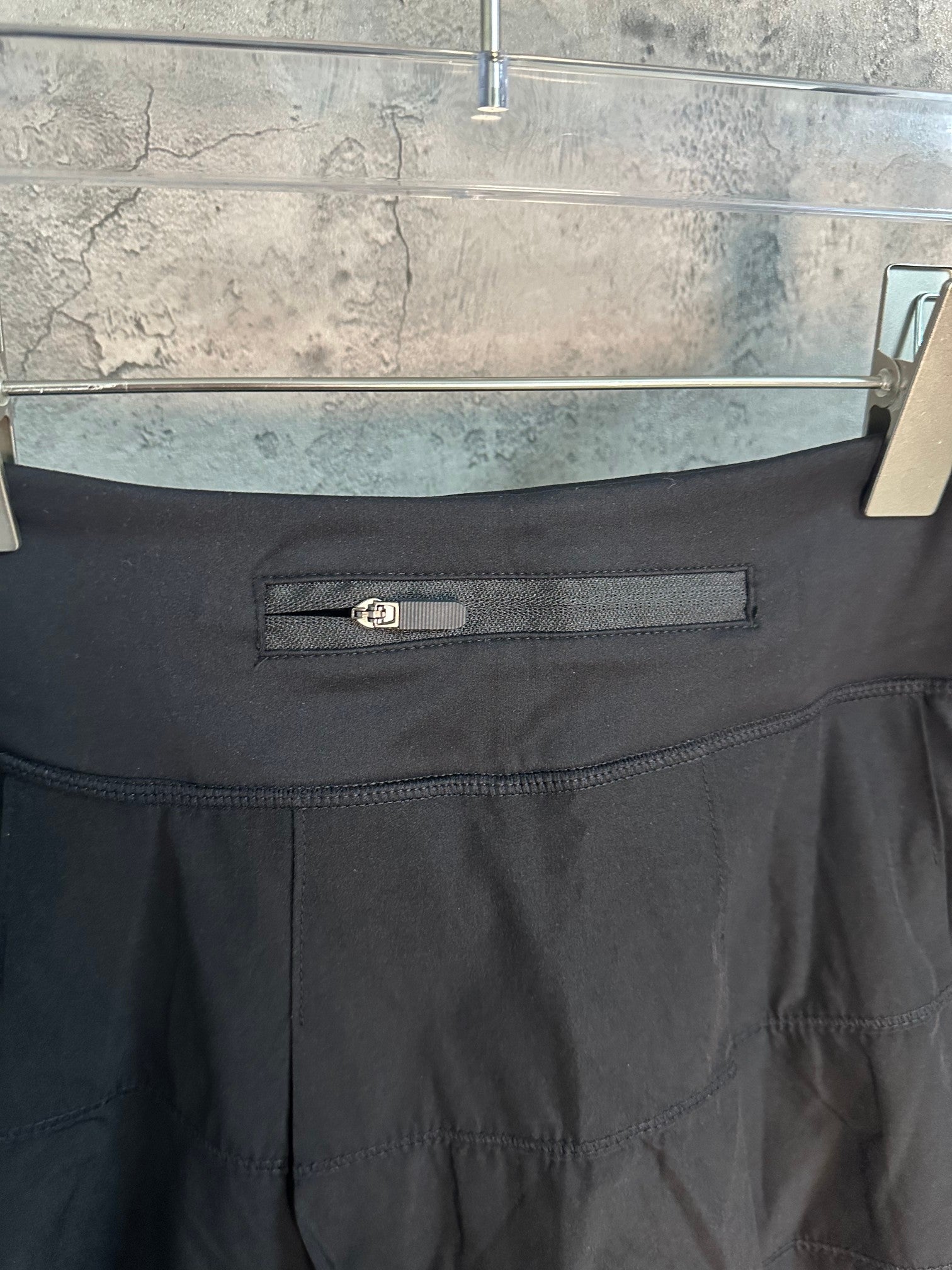Black skort waistband with small belt detail and stitched front pocket