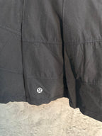 Black skort side panel with small circular logo and curved hem