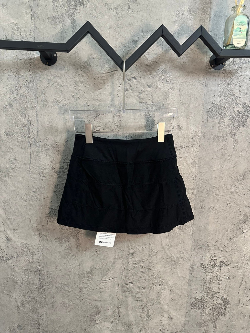 Black athletic skort with structured waistband and flared pleated skirt