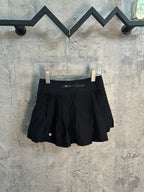 Black athletic skort with pleated front and concealed waistband pocket