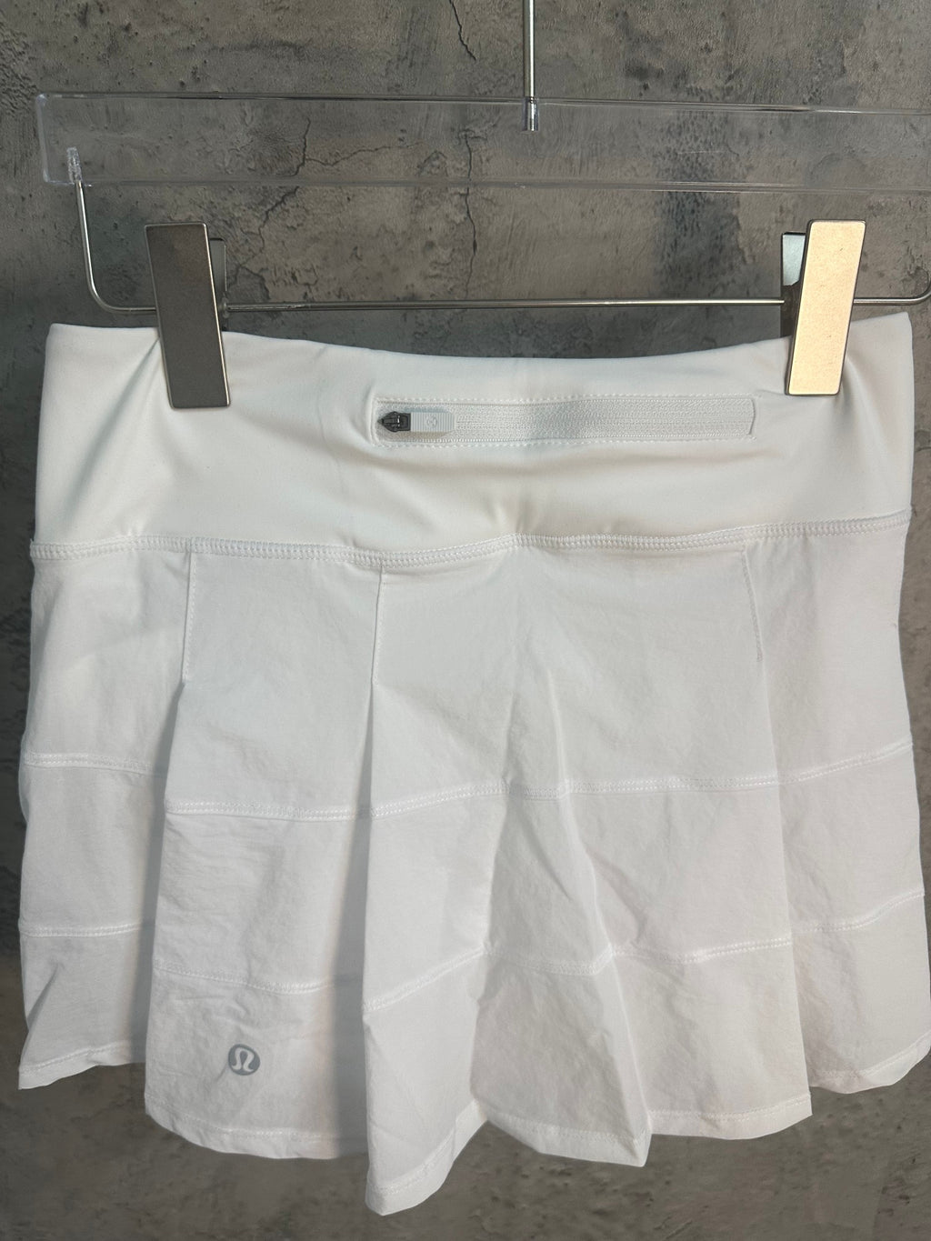 White skirt with elastic waistband and small logo patch at hem