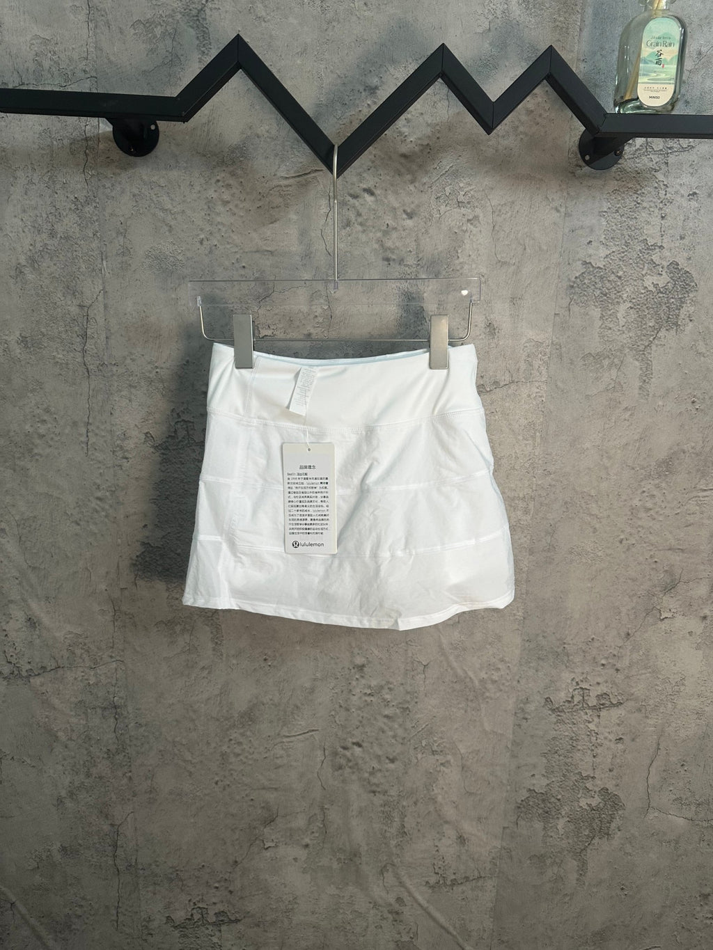 White skirt with tag on waistband and pleated front