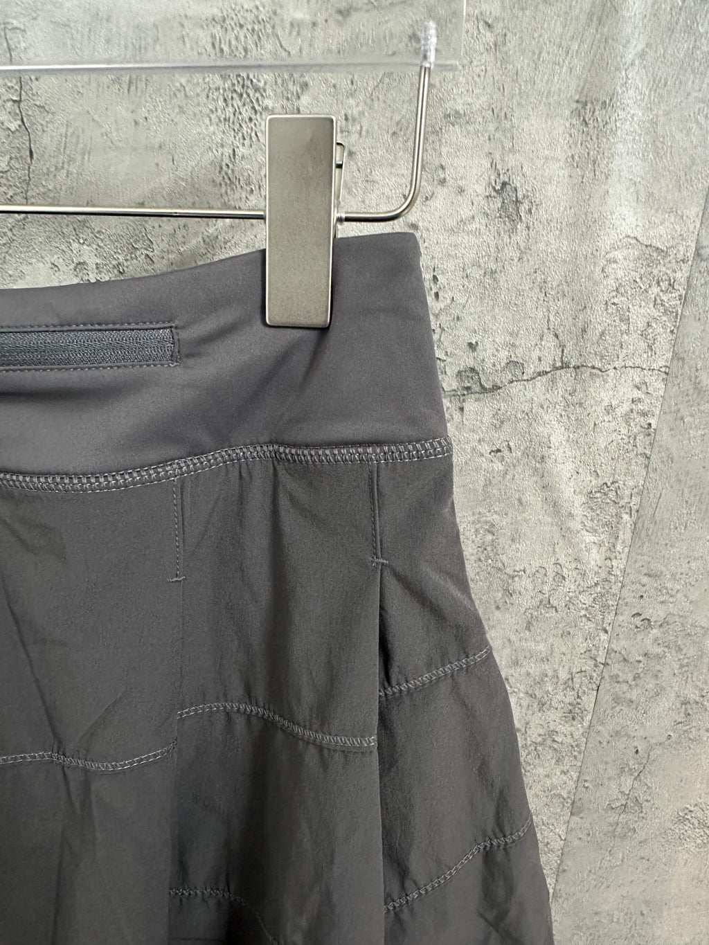 Ralph Lauren skirt side view with stitched seams and tiered panels, dark gray