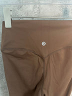 Brown leggings with Omega-style logo at hip