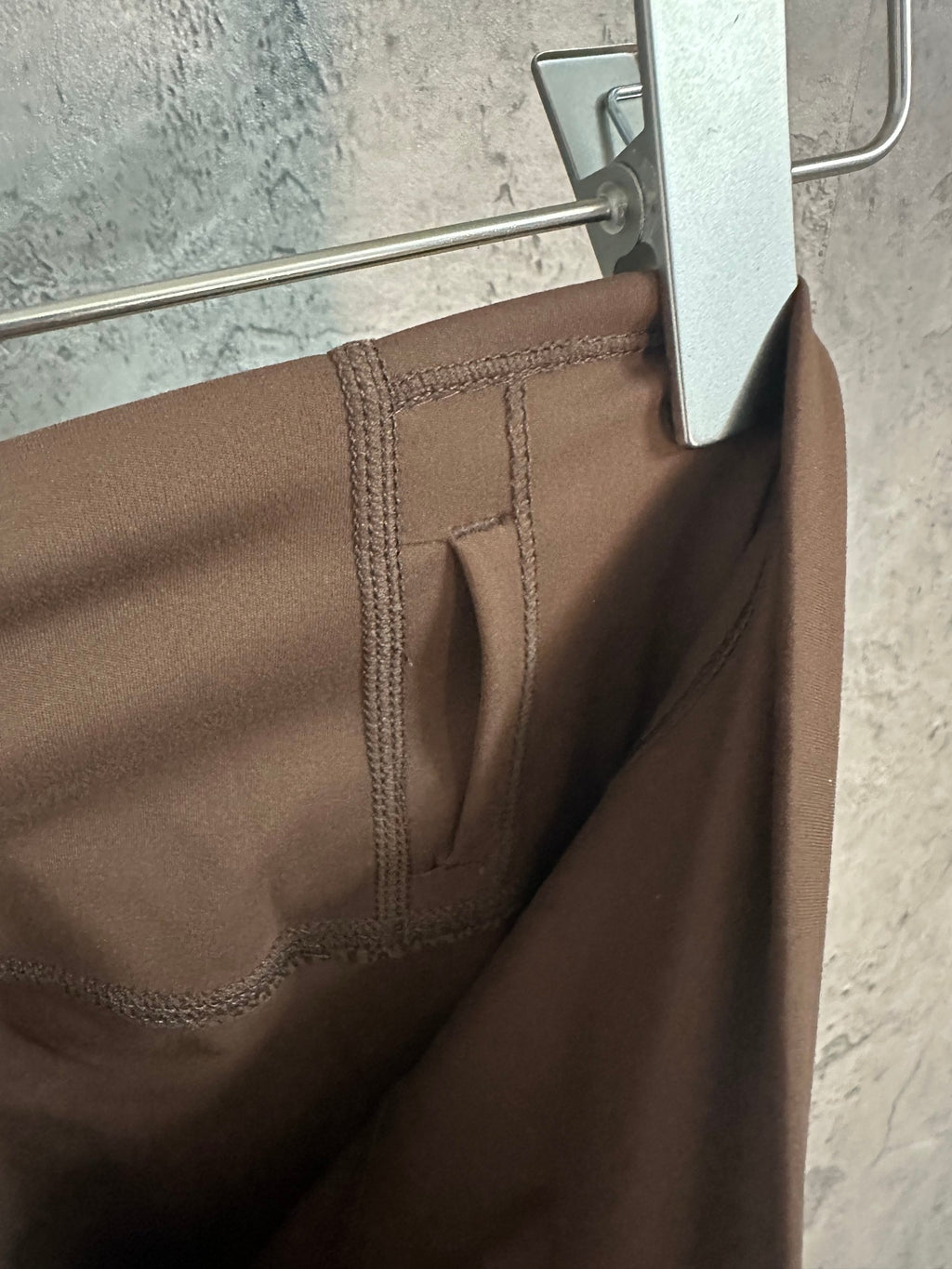Brown pants with stitched back pocket seams on waistband