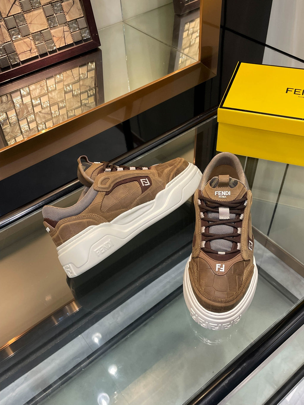 Brown Fendi low-top sneakers with white sole and lace-up front, padded collar