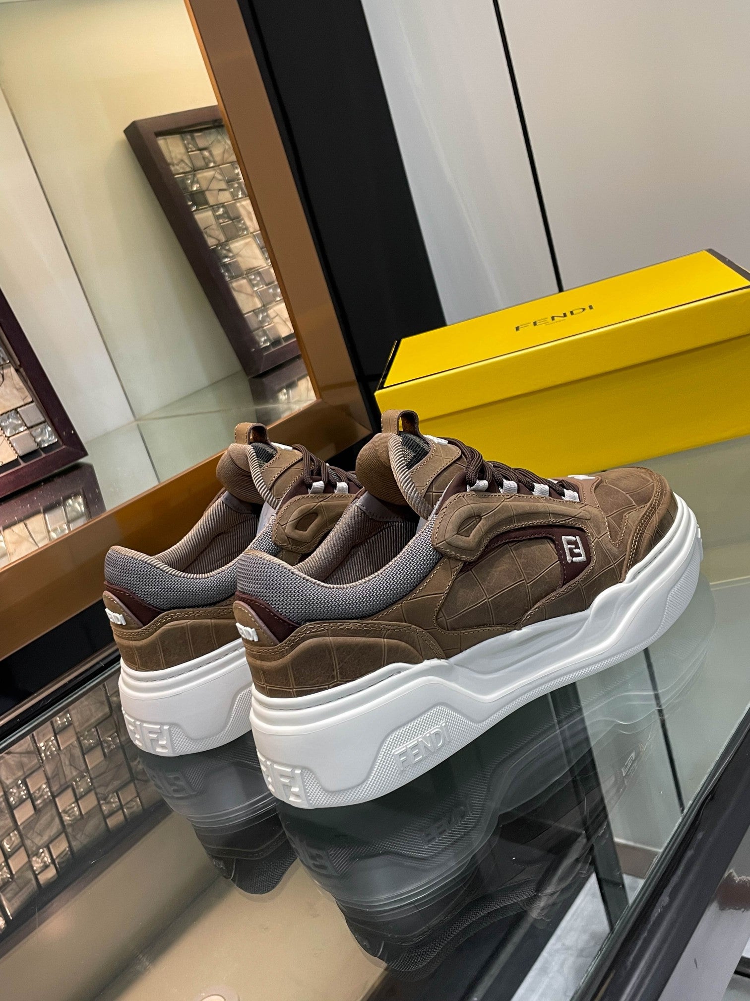 Pair of brown Fendi sneakers with gray lining and chunky white soles