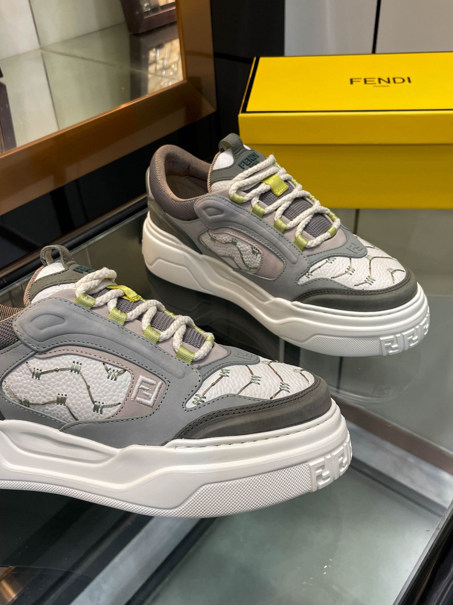 Gray unisex sneakers pair, lace-up with lime trim and white chunky sole, side angle