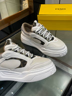 Two white and gray lace-up sneakers on display with chunky sole and logo accents